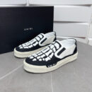 Amiri Skel-Top Slip-On Sneakers in Black and White.