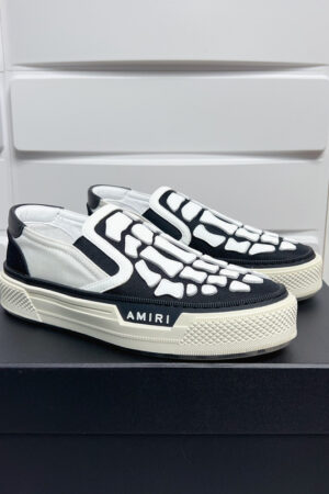 Amiri Skel-Top Slip-On Sneakers in Black and White.