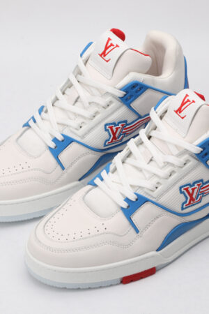 A white low-top sneaker with vibrant blue accents along the side and heel, dynamic red stripes highlighting the side logo, and white laces, set against a clean white background.