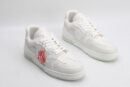 "A pair of PureEssence All-White Luxury Sneakers, viewed from an angle, showcasing their pristine low-top design, white laces, premium white leather upper with subtle textures, and a small red tag hanging from the left shoe
