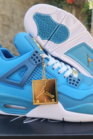 A pair of blue Air Jordan 4 sneakers, showcasing the gold Jumpman hangtag, outsole pattern with blue accents.