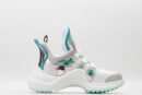 : A pair of black chunky athletic sneakers with brown monogram patterns on the toe and sides, black laces, a prominent black sculptural wavy sole, and a high ankle collar, displayed against a plain white background.