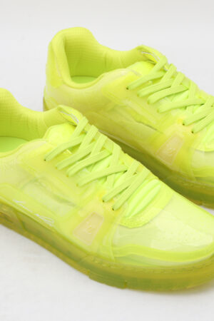 A pair of vibrant neon yellow/lime green translucent low-top sneakers with matching laces and a thick, clear-infused sole, set against a simple white background.