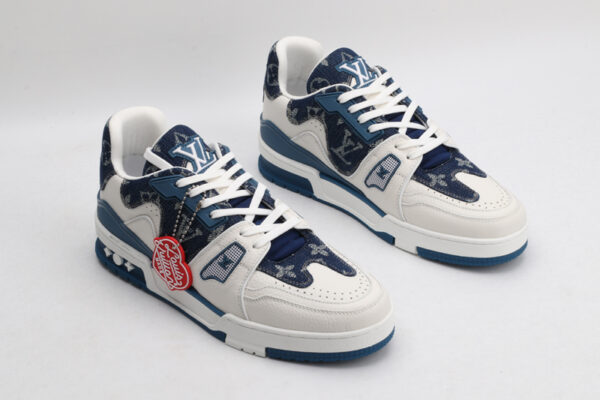 "A pair of IndigoDenim Blue and White Urban Sneakers, viewed at an angle, showcasing their low-top design, white laces, blue patterned denim-like textile sections, white leather overlays, and blue rubber outsole