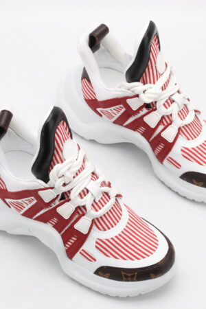 A single white chunky athletic sneaker with iridescent pink and silver overlays, bright aqua blue accents on the collar and outsole, white laces, and a thick, sculptural white sole, displayed from a side profile against a plain white background.