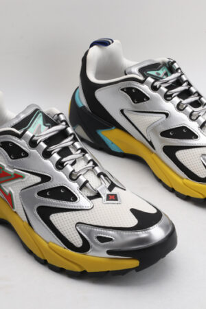 A pair of Louis Vuitton LV Runner Tatic Sneakers, showcasing white mesh, black and silver overlays, a vibrant yellow sole, and blue accents, viewed from a slightly elevated angle.