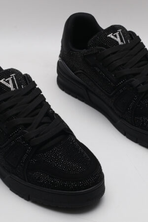 A single all-black Louis Vuitton LV Trainer sneaker, entirely covered in glittering black crystal embellishments, with "VUITTON" subtly visible on the side strap