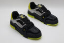 A single black and silver Louis Vuitton LV Trainer sneaker, covered in glittering silver crystal embellishments, with vibrant neon yellow accents on the heel and sole, and a prominent gold LV logo on the side.
