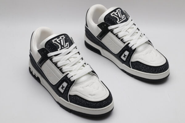 A single black and white Louis Vuitton LV Trainer sneaker, covered in glittering black crystal embellishments, with "VUITTON" written on the side strap