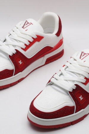 A single red and white Louis Vuitton LV Trainer sneaker, covered in glittering red crystal embellishments, with "VUITTON" visible on the outsole.