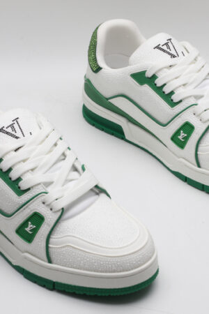 A single white and green Louis Vuitton LV Trainer sneaker, covered in glittering green crystal embellishments, with "VUITTON" visible on the outsole.