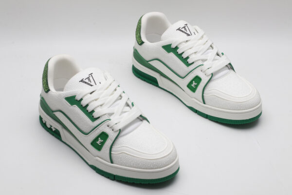 A single white and green Louis Vuitton LV Trainer sneaker, covered in glittering green crystal embellishments, with "VUITTON" visible on the outsole.