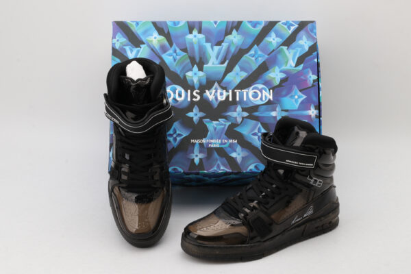 A pair of translucent black Louis Vuitton LV Trainer Up high-top sneakers with velcro straps, black laces, and a black sole