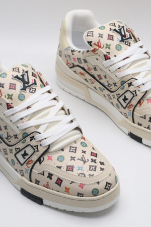 A single beige Louis Vuitton LV Trainer Low-Top Sneaker with an all-over multi-color Louis Vuitton Monogram pattern, showcasing its detailed design and white sole.