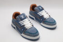A single blue denim and tan Louis Vuitton LV Trainer Low-Top Sneaker, showcasing its textured denim upper, tan leather heel, and white laces