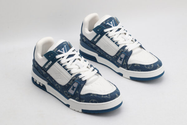 A pair of Louis Vuitton LV Trainer Low-Top Sneakers in blue denim and white, viewed from an elevated angle, showcasing both shoes with blue denim panels and white leather details.