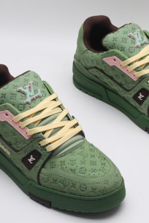 A single green Louis Vuitton LV Trainer Low-Top Sneaker, showcasing its embossed monogram on green leather, pink accents, and brown sole.