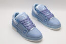 A pair of light blue Louis Vuitton LV Trainer Low-Top Sneakers, showcasing their full design from a slight angle.