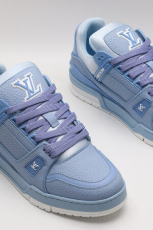 A pair of light blue Louis Vuitton LV Trainer Low-Top Sneakers, showcasing their full design from a slight angle.