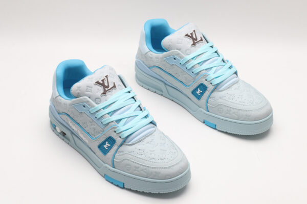 A single light blue Louis Vuitton LV Trainer Low-Top Sneaker, showcasing its embossed monogram on light blue leather, light blue and darker blue accents, and white sole.