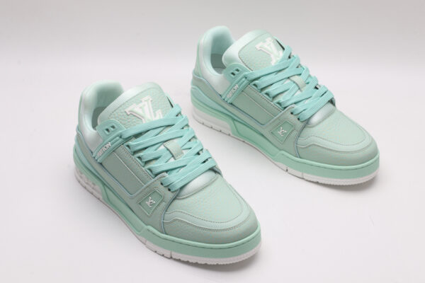 A pair of mint green Louis Vuitton LV Trainer Low-Top Sneakers, showcasing their full design from a slight angle.