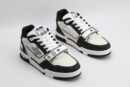 A pair of Louis Vuitton LV Trainer Mid-Top Sneakers in white and black monogram canvas, viewed from an elevated angle, showcasing both shoes with black monogram canvas panels, white and cream leather details, and a prominent white strap.