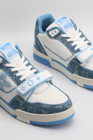 A pair of Louis Vuitton LV Trainer Mid-Top Sneakers in white and blue denim, viewed from an elevated angle, showcasing both shoes with blue denim panels, white leather details,