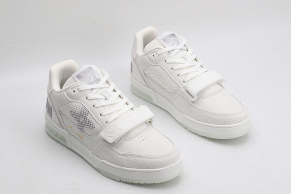 A pair of Louis Vuitton LV Trainer Mid-Top Sneakers in white and grey, viewed from an elevated angle, showcasing both shoes with white leather and mesh panels, grey suede accents, and a prominent white strap.