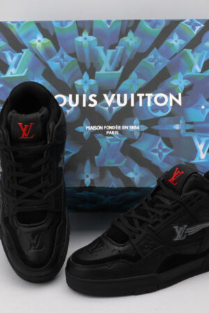 A pair of all-black Louis Vuitton LV Trainer sneakers with subtle grey LV monogram patterns and red accents on the tongue