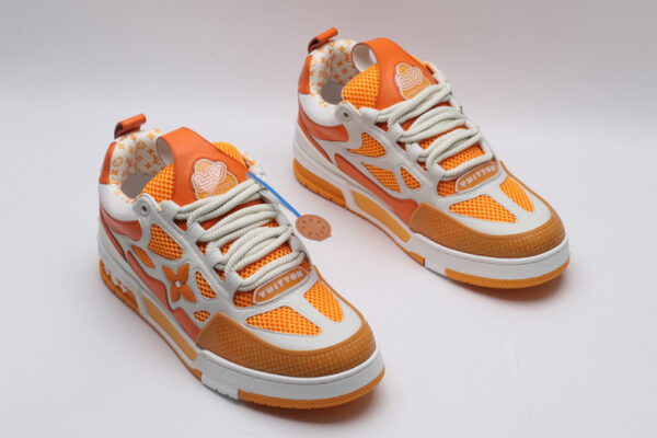 A single orange and white Louis Vuitton LV Trainer sneaker, showcasing its vibrant color blocking, mesh panels, and robust sole.