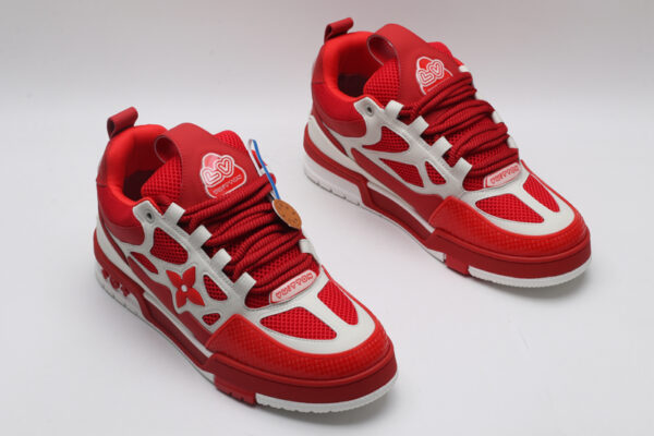 A single red and white Louis Vuitton LV Trainer sneaker, showcasing its vibrant color blocking, mesh panels, and robust sole.