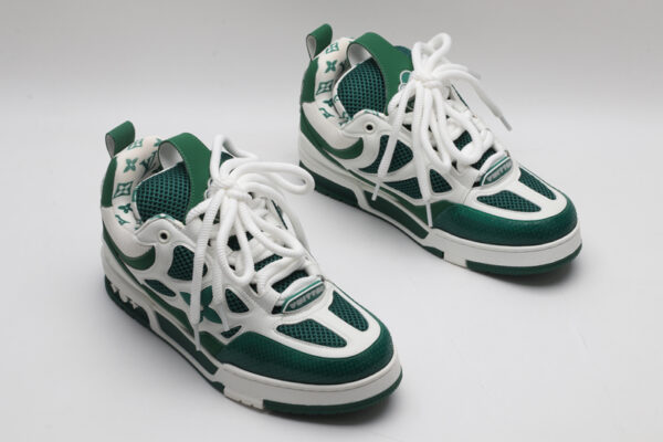 A single white and green Louis Vuitton LV Trainer sneaker, showcasing its bicolor design, mesh panels, and robust outsole.