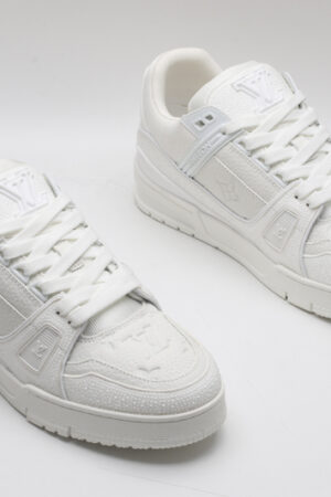 A single white and grey Louis Vuitton LV Trainer sneaker, showcasing its clean bicolor design, textured panels, and robust outsole.