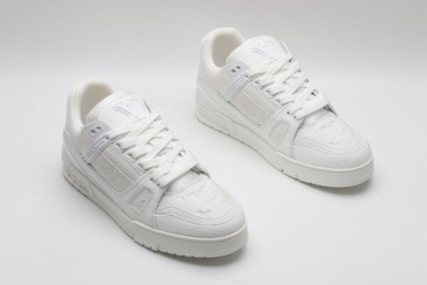 A single white and grey Louis Vuitton LV Trainer sneaker, showcasing its clean bicolor design, textured panels, and robust outsole.