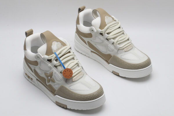 A single white and tan Louis Vuitton LV Trainer sneaker, showcasing its clean color blocking, mesh panels, and robust sole.