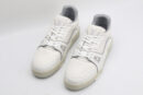 A pair of white Louis Vuitton LV Trainer sneakers with light grey accents and a beige outsole