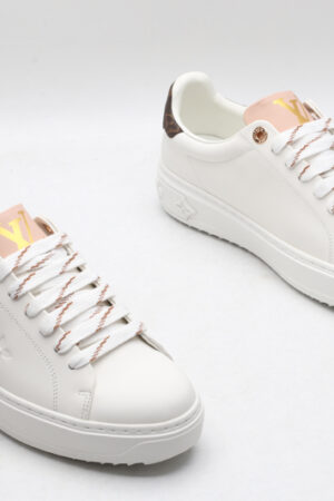 A pair of white Louis Vuitton Stellar Low-Top Sneakers with pink tongues and brown monogrammed heel tabs, viewed from a high angle