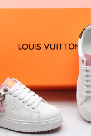 A top-down view of a pair of white Louis Vuitton Stellar Low-Top Sneakers, featuring pink tongues with gold LV logos and brown monogrammed heel tabs.