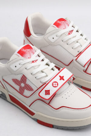A pair of CrimsonFlash White and Red Sneakers, viewed at an angle, showcasing their low-top design, white laces, crisp white leather upper, vibrant red accents on the heel, outsole, and strap, and breathable white mesh side panels."