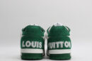 "A pair of LuxStride Elite Green and White Athletic Sneakers, viewed from the front, showcasing their low-top design, white laces, green suede accents, white leather panels, and distinctive patterned strap across the vamp