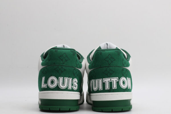 "A pair of LuxStride Elite Green and White Athletic Sneakers, viewed from the front, showcasing their low-top design, white laces, green suede accents, white leather panels, and distinctive patterned strap across the vamp