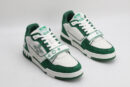 "A pair of LuxStride Elite Green and White Athletic Sneakers, viewed from the front, showcasing their low-top design, white laces, green suede accents, white leather panels, and distinctive patterned strap across the vamp