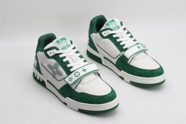 "A pair of LuxStride Elite Green and White Athletic Sneakers, viewed from the front, showcasing their low-top design, white laces, green suede accents, white leather panels, and distinctive patterned strap across the vamp