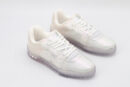 A pair of luminous iridescent holographic low-top sneakers with a clear, color-shifting upper, white laces, and a textured translucent sole, presented against a pure white background