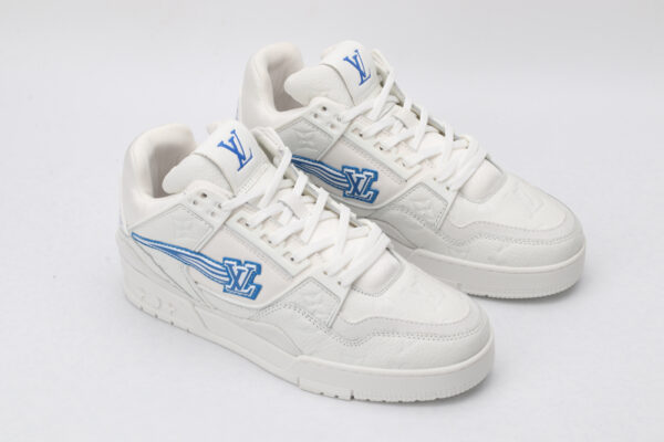 A pair of white low-top sneakers featuring a subtle all-over monogram pattern, prominent blue logos on the tongue and side with a dynamic striped effect, and white laces, set against a plain white background.