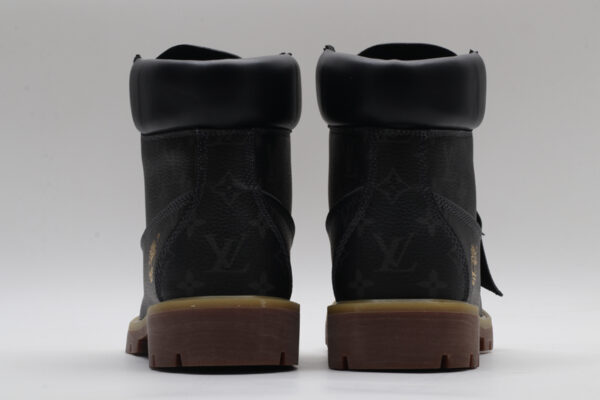 A pair of olive green Timberland x Louis Vuitton collaborative waterproof boots, featuring the Timberland tree logo and subtle Louis Vuitton monogram debossing on the upper.