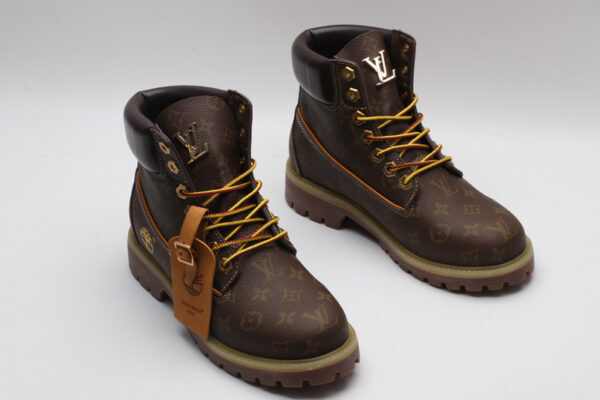 A single brown Timberland x Louis Vuitton collaborative waterproof boot, featuring the all-over Louis Vuitton monogram pattern, yellow and red laces, and the Timberland tree logo.
