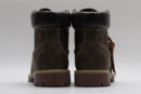 A single brown Timberland x Louis Vuitton collaborative waterproof boot, featuring the all-over Louis Vuitton monogram pattern, yellow and red laces, and the Timberland tree logo.