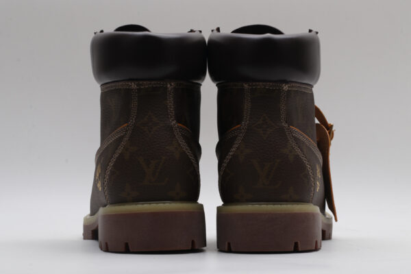 A single brown Timberland x Louis Vuitton collaborative waterproof boot, featuring the all-over Louis Vuitton monogram pattern, yellow and red laces, and the Timberland tree logo.