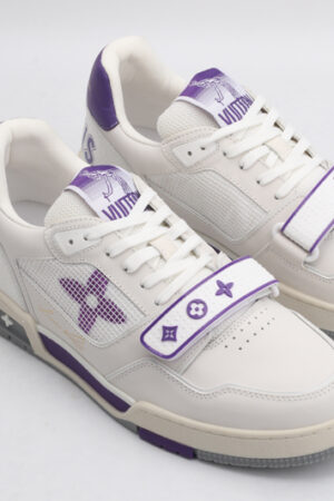 A pair of TwilightGlow Off-White and Purple Sneakers, viewed at an angle, showcasing their low-top design, white laces, off-white leather upper, vibrant purple accents on the collar and outsole, mesh side panels, and distinctive purple and white strap across the vamp
